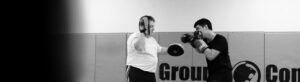 Man practicing punches with another man holding strike pads
