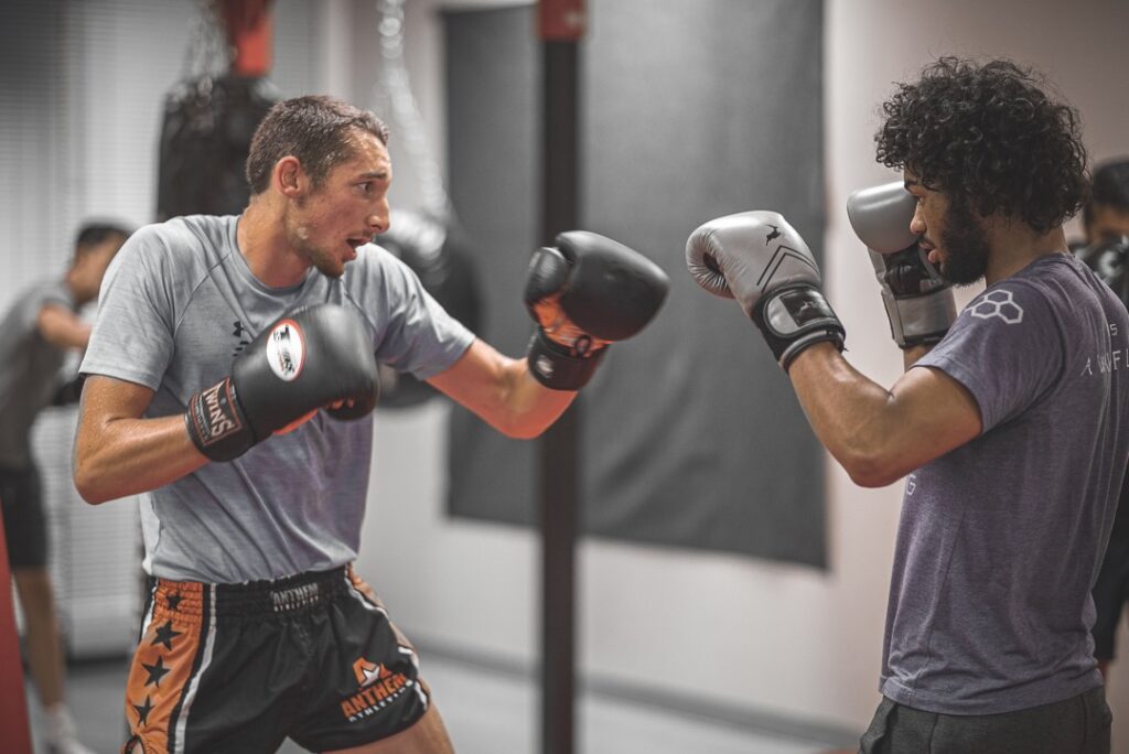 Two men boxing each other in a class