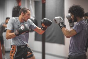 Two men boxing each other in a class