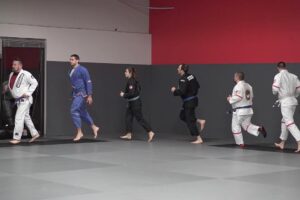 Martial arts students jogging around the mat