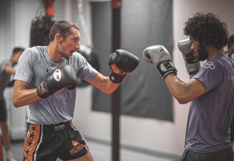 Two men boxing each other in a class